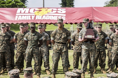 U.S. Marine Corps Sgt. Tyler Cooper, U.S. Marine Corps Sgt. Tyler Cooper, with Truck Company, Headquarters Battalion, 3d Marine Division, is awarded the drill trophy for his platoon during a drill competition at the Courtney Bowl on Camp Courtney, Okinawa, Japan, March 31, 2017. Headquarters Company, Truck Company, and Communications Company engaged in a competition against each other for a drill trophy and to aid in preparation for an upcoming commanding general inspection.  (U.S. Marine Corps photo by MCIPAC Combat Camera Lance Cpl.  Jesus McCloud)