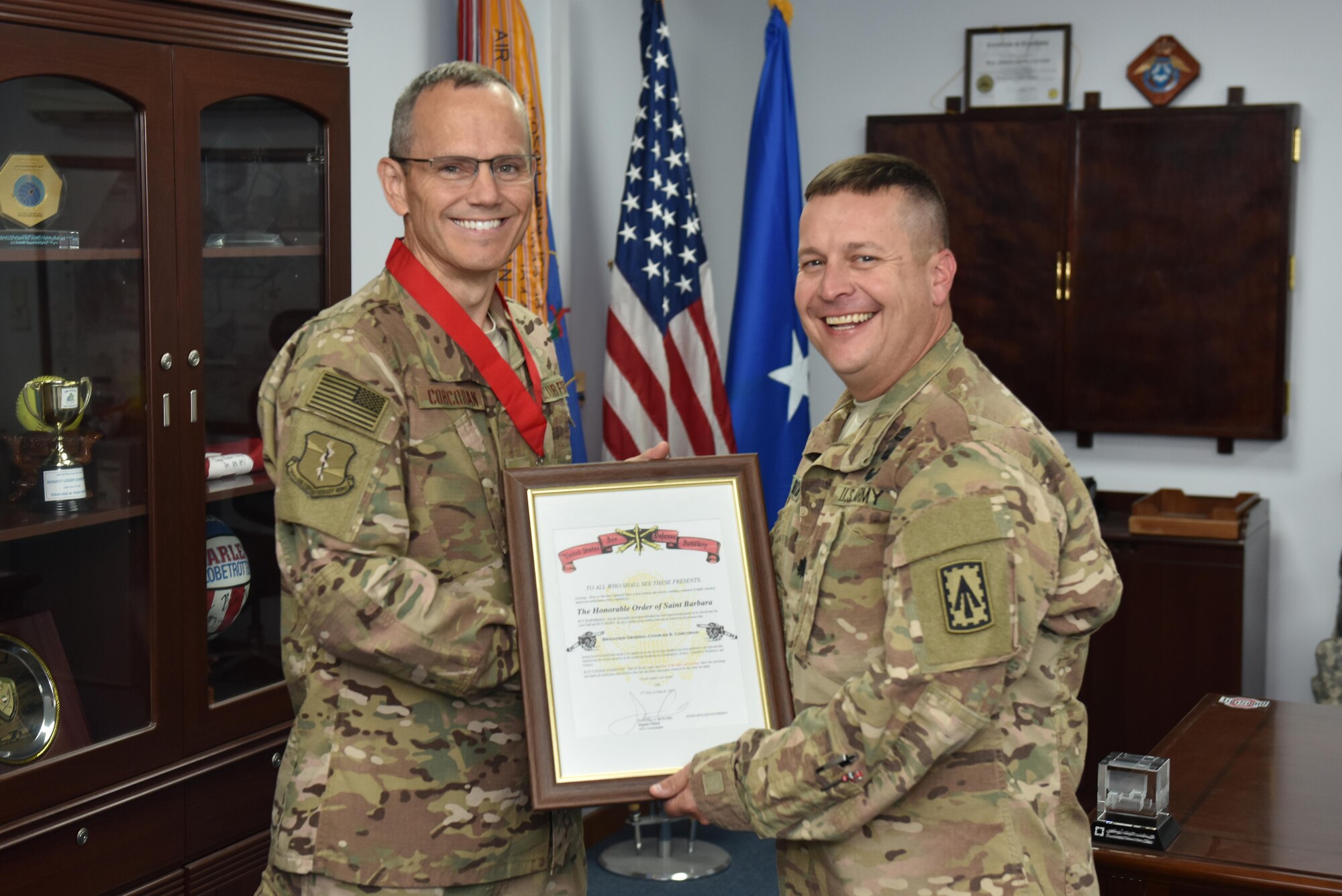 Lt. Col. Christopher Brough, commander of the 3rd Battalion, 4th Air Defense Artillery Regiment, presents 380th Air Expeditionary Wing Commander Brig. Gen. Charles Corcoran with the Honorable Order of Saint Barbara at an undisclosed location in southwest Asia, June 16, 2017.
