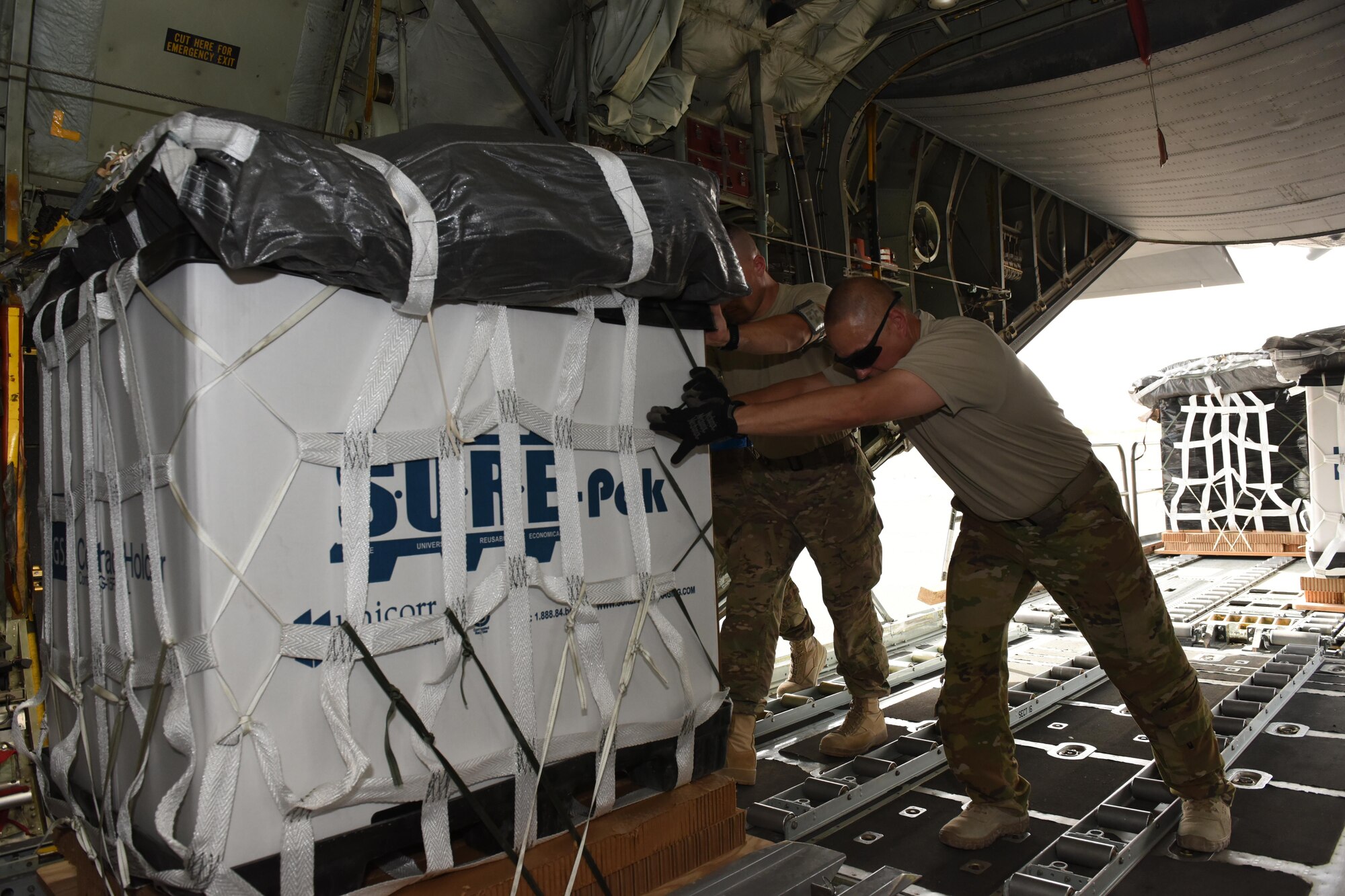 Senior Airman John Cox, an air transportation specialist with the 386th Expeditionary Logistics Readiness Squadron, and Chief Master Sgt. James Traficante, a loadmaster with the 737th Expeditionary Airlift Squadron, work together to push a container delivery system into the cargo bay of a C-130 Hercules in preparation for an air drop at an undisclosed location in Southwest Asia, over the weekend. Providing the fuel that keeps the fight going, the 386th Air Expeditionary Wing has delivered more than 80 tons of food, water and other supplies to various supported forces throughout the U.S. Air Forces Central Command area of responsibility in support of Combined Joint Task Force - Operation Inherent Resolve ground troops. (U.S. Air Force photo/Tech. Sgt. Jonathan Hehnly)