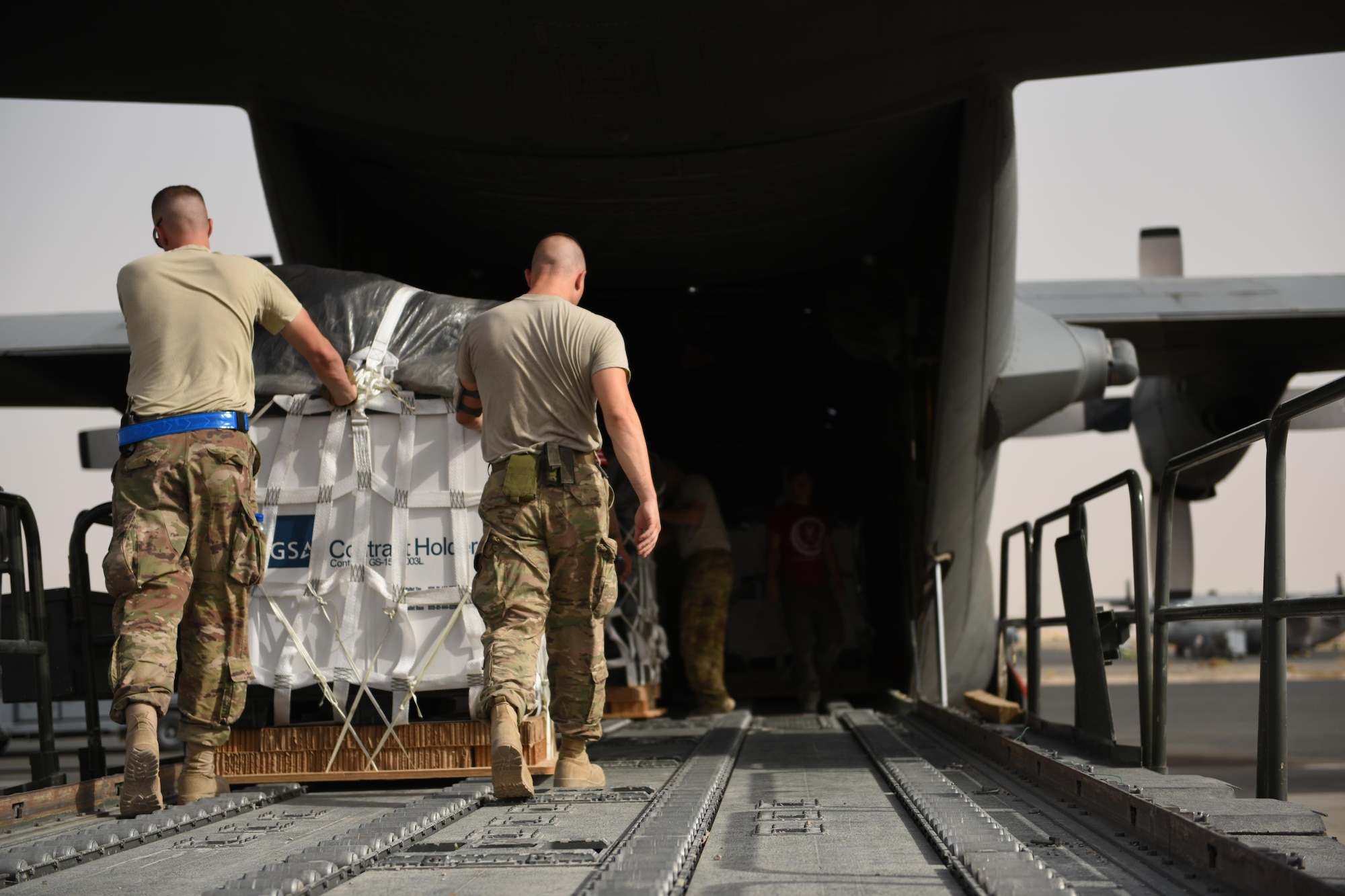 Air transportation specialists with the 386th Expeditionary Logistics Readiness Squadron push a container delivery system off a 60k Tunner loader and into the cargo bay of a C-130 Hercules in preparation for an air drop at an undisclosed location in Southwest Asia, over the weekend. Providing the fuel that keeps the fight going, the 386th Air Expeditionary Wing has delivered more than 80 tons of food, water and other supplies to various supported forces throughout the U.S. Air Forces Central Command area of responsibility in support of Combined Joint Task Force - Operation Inherent Resolve ground troops. (U.S. Air Force photo/Tech. Sgt. Jonathan Hehnly)