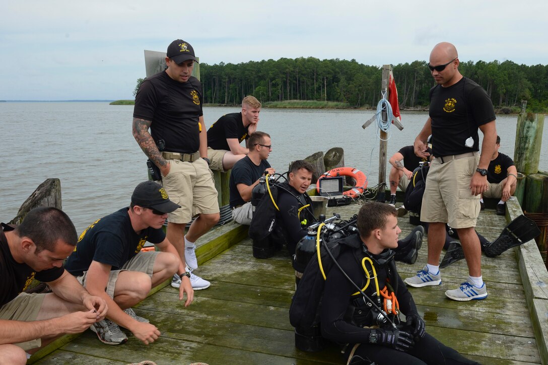U.S. Army Soldiers assigned to the 74th Engineer Dive Detachment, 92nd Engineer Battalion, review what to look for when inspecting the piers at Third Port during a diving mission at Joint Base Langley-Eustis, Va., June 20, 2017. The divers regularly inspect the piers to determine if repairs are needed to keep the port operational. (U.S. Air Force photo/Airman 1st Class Kaylee Dubois)