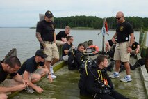 U.S. Army Soldiers assigned to the 74th Engineer Dive Detachment, 92nd Engineer Battalion, review what to look for when inspecting the piers at Third Port during a diving mission at Joint Base Langley-Eustis, Va., June 20, 2017. The divers regularly inspect the piers to determine if repairs are needed to keep the port operational. (U.S. Air Force photo/Airman 1st Class Kaylee Dubois)