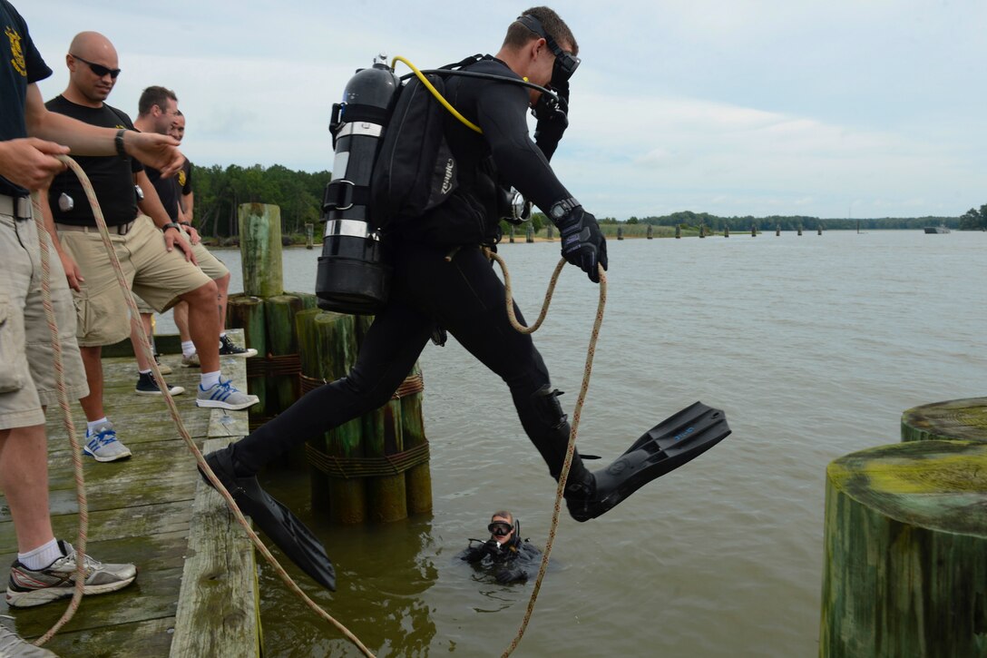 U.S. Army Pfc. Kyle Grimes, 74th Engineer Dive Detachment, 92nd Engineer Battalion second class diver, jumps into the James River to inspect Third Port’s piers during a diving mission at Joint Base Langley-Eustis, Va., June 20, 2017. To prevent massive reconstruction projects to occur in the future, the divers look closely for any damage or irregularities they can easily fix while inspecting the piers. (U.S. Air Force photo/Airman 1st Class Kaylee Dubois)