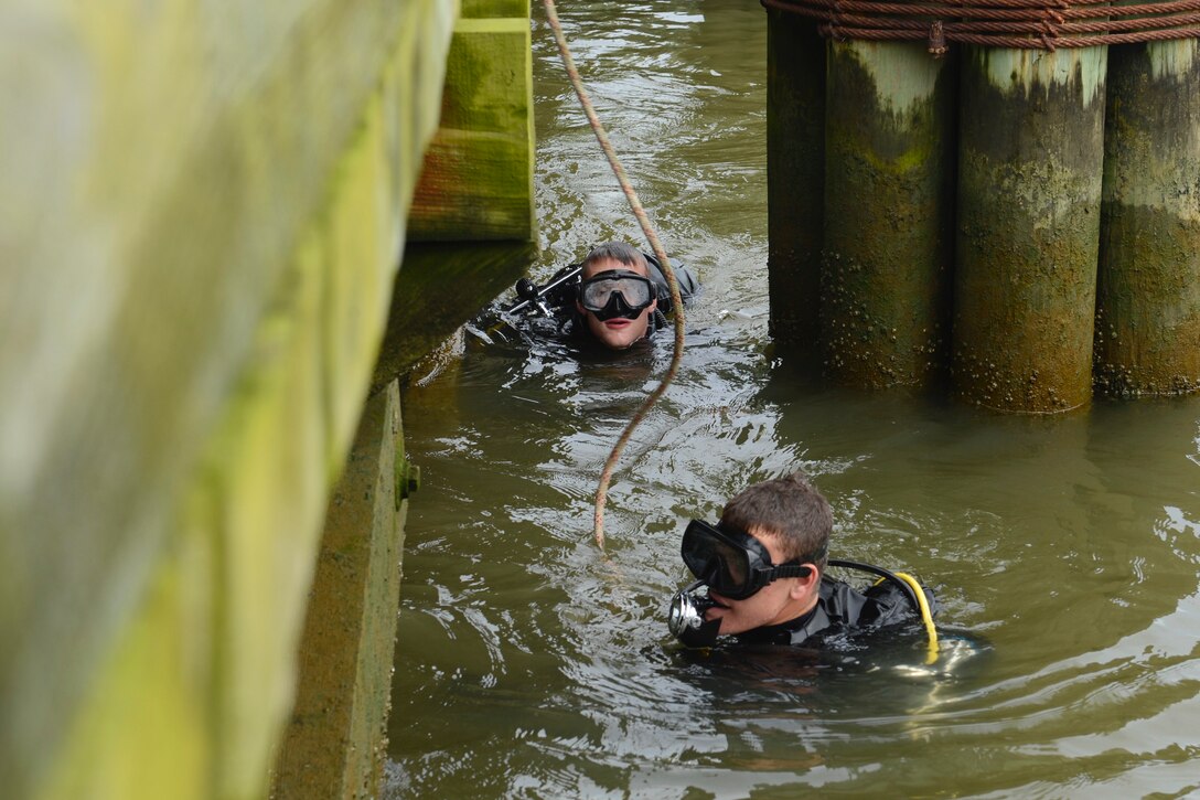 U.S. Army Pfc. Kyle Grimes, front, and Pfc. Samuel Ladd, 74th Engineer Dive Detachment, 92nd Eng. Battalion second class divers, inspect Third Port’s piers during a diving mission at Joint Base Langley-Eustis, Va., June 20, 2017. The detachment uses inspection assignments to train younger divers and help them improve their techniques. (U.S. Air Force photo/Airman 1st Class Kaylee Dubois)