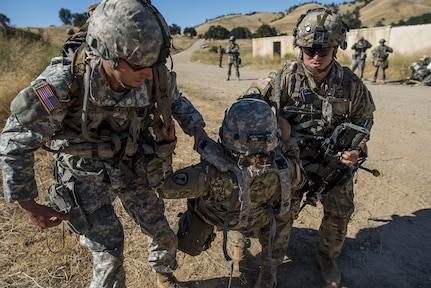 U.S. Army Reserve Soldiers from the 339th Military Police Company (Combat Support), headquartered in Davenport, Iowa, carry an "injured" battle-buddy to safety during a route reconnaissance training lane a Warrior Exercise (WAREX) held at Fort Hunter Liggett, California, June 19. The MP company's Soldiers had to relocate their tactical assembly areas in the field multiple times as they reconnoitered different areas of their operational environment, while fighting against temperatures reaching 100-plus degrees daily. (U.S. Army Reserve photo by Master Sgt. Michel Sauret)