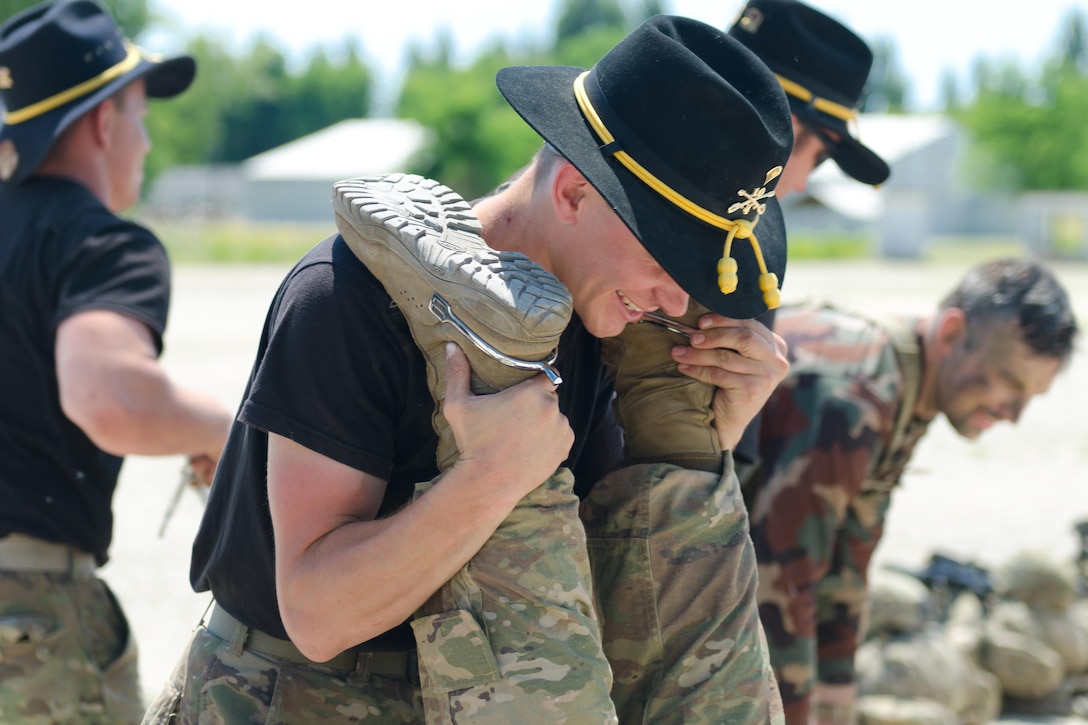 A soldier assigned to Apache Troop, 4th Squadron, 10th Cavalry Regiment, holds the legs of a newly inducted member of the Order of the Spur following a spur ride in Tata, Hungary, June 1, 2017. Army photo by Capt. John W. Strickland