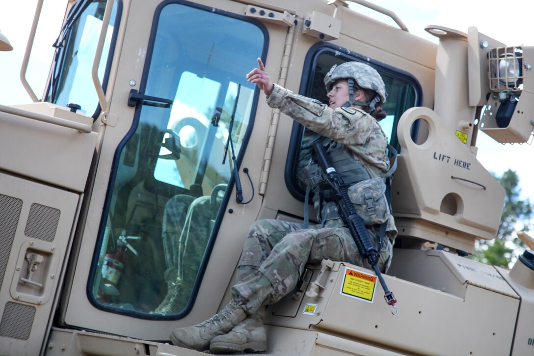 South Dakota Army National Guard Sgt. Kymberlee Hassebroek, foreground, instructs Spc. Justin Barden where to level dirt using a D7 Dozer in support of Golden Coyote, Lead, S.D., June 14, 2017. Hassebroek and Barden are assigned to the 842nd Engineer Company. Army photo by Spc. Jeffery Harris