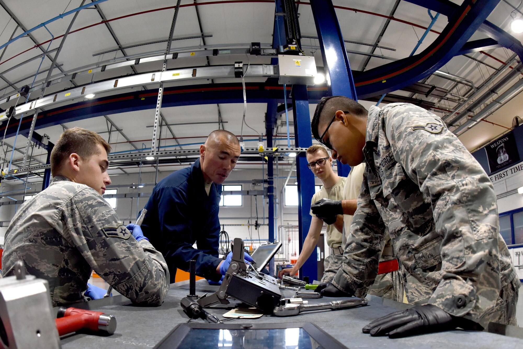 Aircraft armament specialists from the 48th Munitions Squadron are instructed on repairing interface piston systems at Royal Air Force Lakenheath, England, June 13. Maintain and inspect the armament equipment (U.S. Air Force photo/Airman 1st Class John A. Crawford)