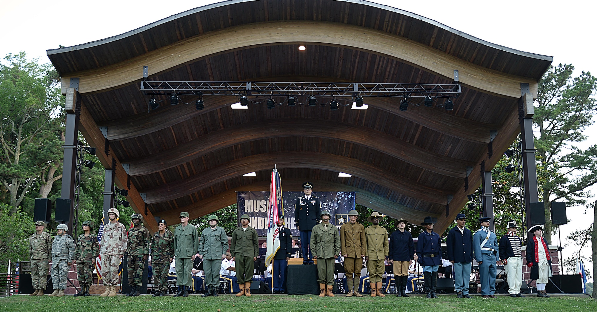 U.S. Army Soldiers from the 7th Transportation Brigade (Expeditionary) conduct a streamer ceremony during the Army 242nd birthday, Music Under the Stars celebration at Joint Base Langley-Eustis, Va., June 15, 2017. The Soldiers wore uniforms of the respective time periods when presenting streamers to be attached to the Army guidon. (U.S. Air Force photo/Staff Sgt. Teresa J. Cleveland)