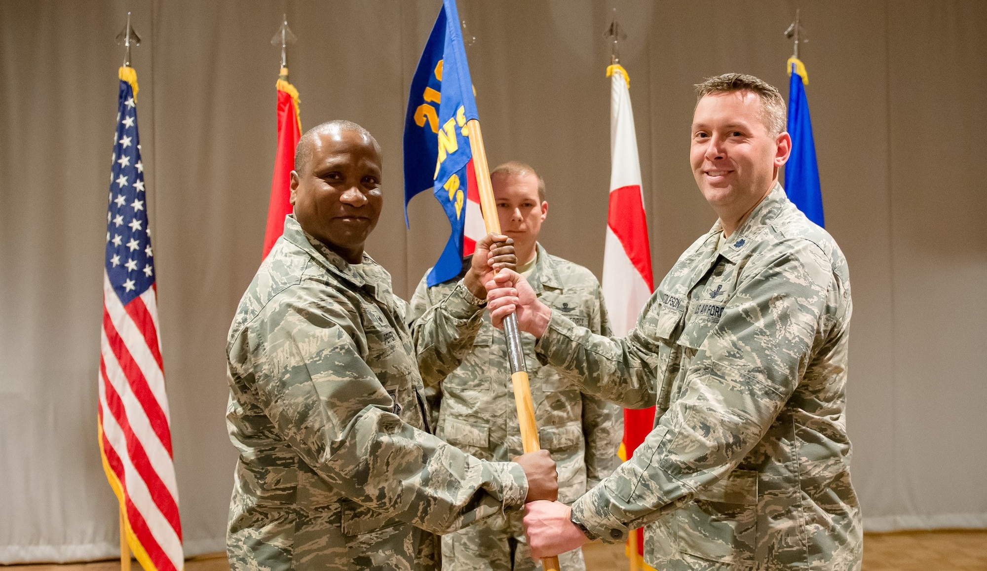 Col. Devin Pepper, 21st Operations Group commander, hands the 12th Space Warning Squadron guidon Lt. Col. Carl Bottolfson at a change of command ceremony, June 8, 2017, at Thule Air Base, Greenland. The 12th SWS provides critical, real-time warning of ballistic missile attacks against North America and detects, tracks and identifies earth-orbiting objects in support of U.S. Strategic Command's space control mission. (Courtesy Photo)