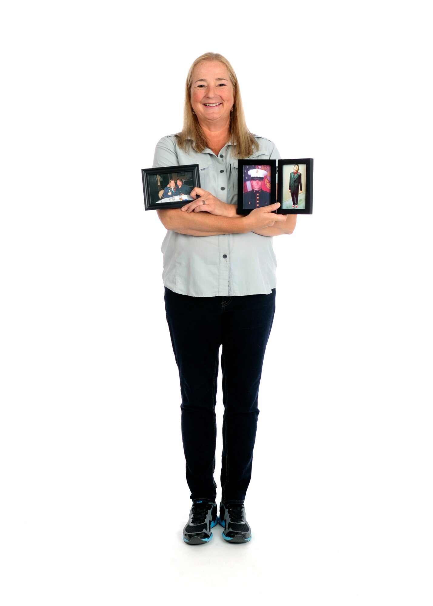Carol Wagner, 325th Fighter Wing advanced program office personnel security manager, holds sentimental photographs of her family at Tyndall Air Force Base, Fla., June 8, 2017. The photographs symbolize those who stood by her side during her battle with Leukemia. (U.S. Air Force photo by Airman 1st Class Delaney Rose/ Released)