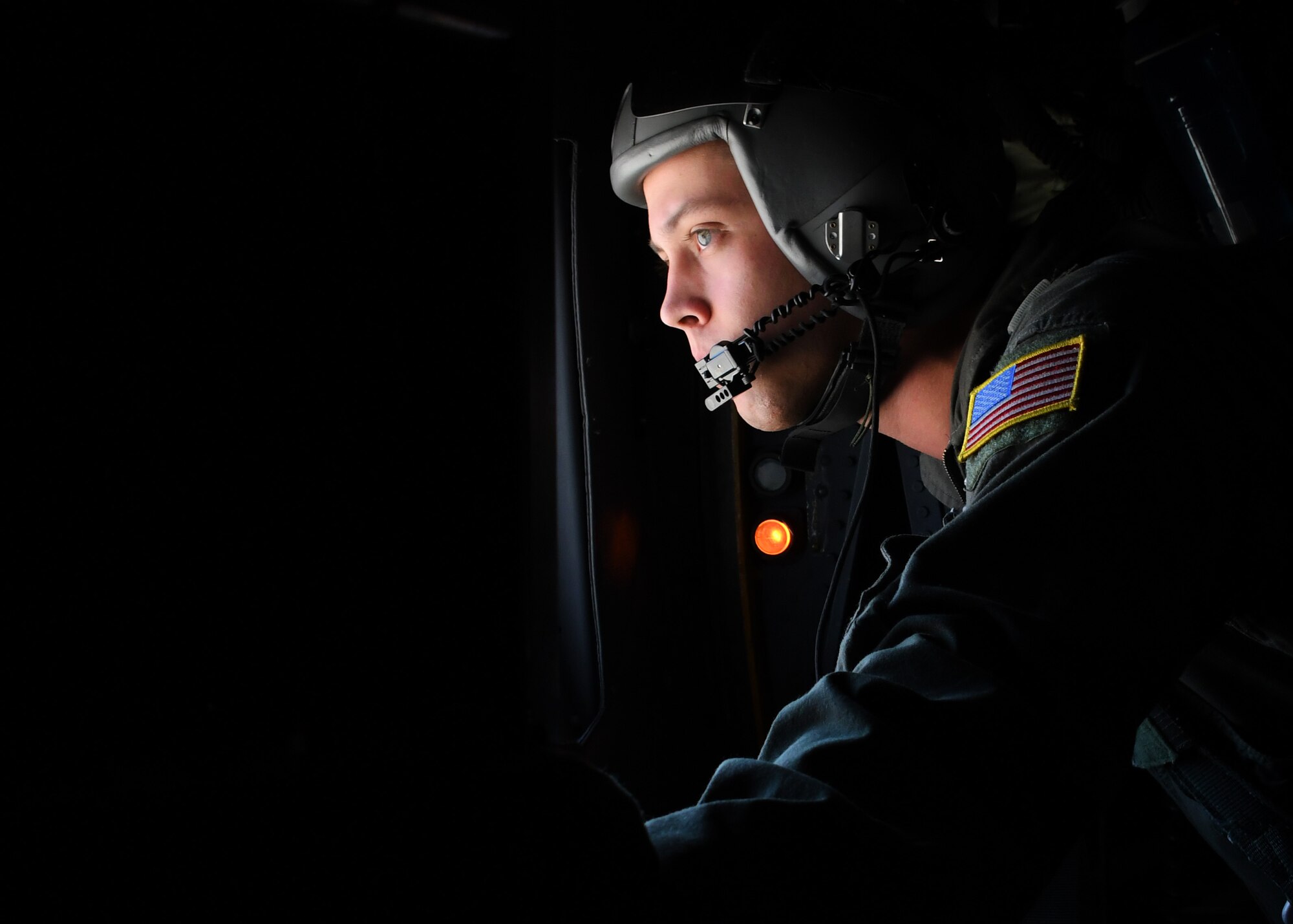 U.S. Air Force Senior Airman Ryan Fenimore, a 700th Airlift Squadron loadmaster, looks outside of a window on a C-130 Hercules during an exercise outside of Nellis Air Force Base, Nevada, June 10, 2017. Fenimore was on an aircrew from the 94th Airlift Wing that participated in the Joint Forcible Entry exercise hosted by the United States Air Force Weapons School graduating students, which brought together more than 100 aircraft to train working in large formations in a contested degraded environment. (U.S. Air Force photo by Staff Sgt. Miles Wilson)