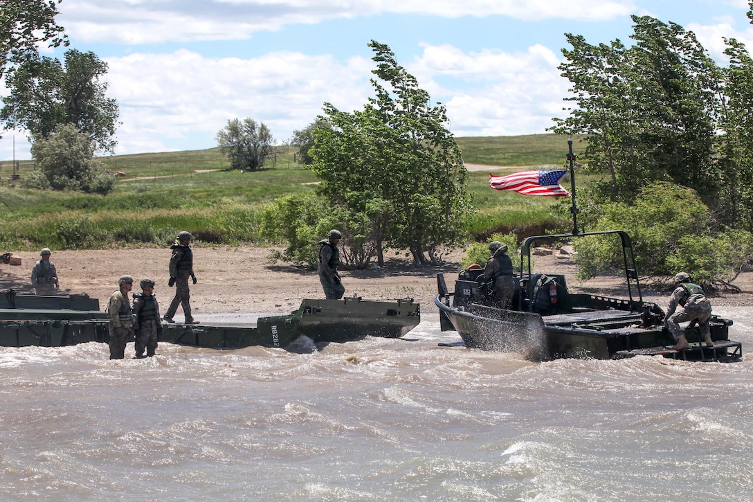 South Dakota Army National Guardsmen use an Mk2 bridge erection boat to move an Improved Ribbon Bridge onto the beach in support of Golden Coyote, Orman, S.D., June 14, 2017. Army photo by Spc. Jeffery Harris