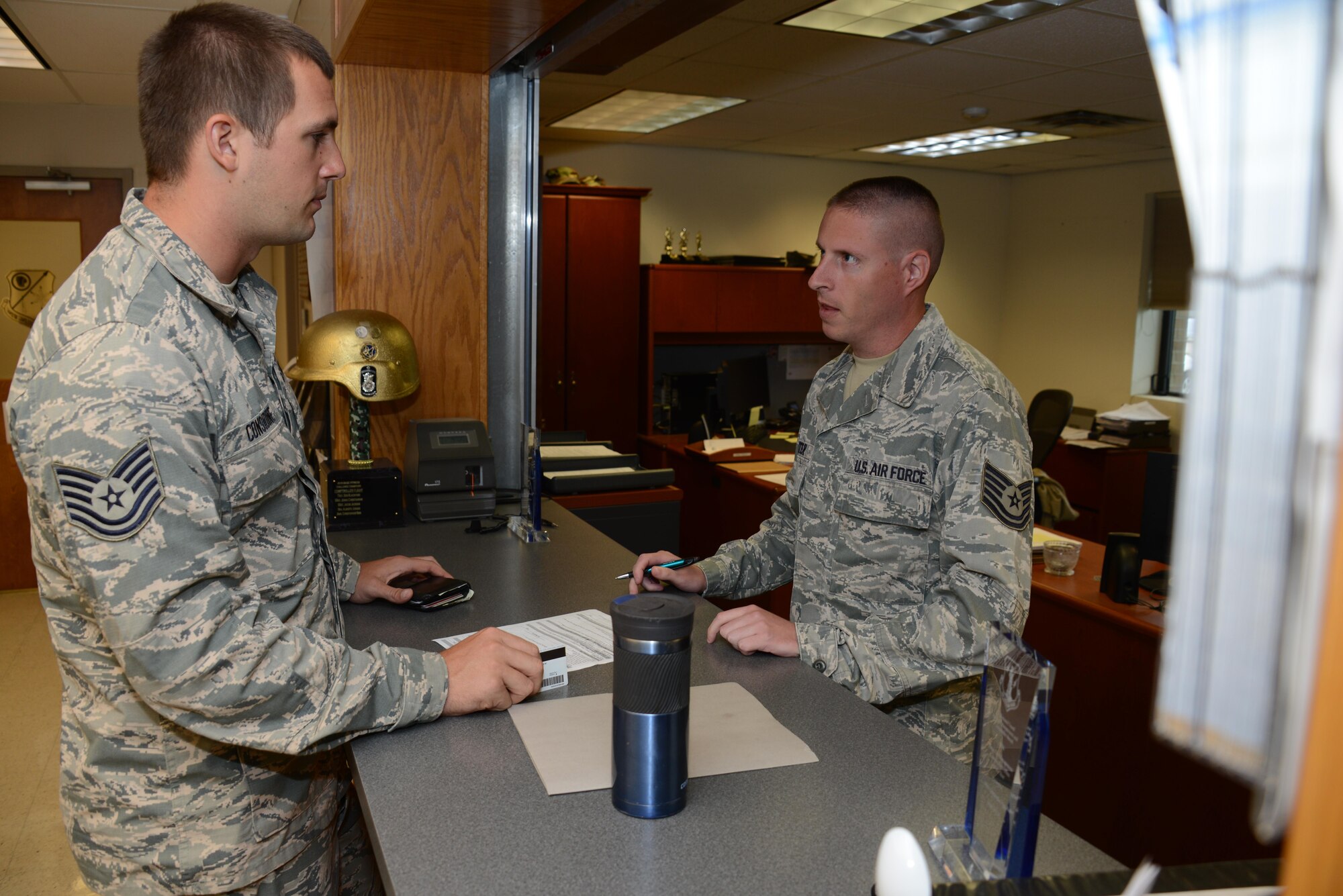 Tech. Sgt. Mike Considine talks with Tech. Sgt. Mike Winter who is a Travel Pay Technician with the Iowa Air National Guard’s 185th Air Refueling Wing at the Wing’s Financial Management Office in Sioux City, Iowa on June 21, 2017. 
U.S. Air National Guard photo by Master Sgt. Vincent De Groot/185ARW Wing PA