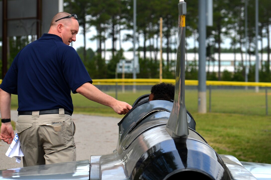 U.S. Air Force Tech. Sgt. Ryan Lundin, 337th Recruiting Squadron recruiter, escorts an attendee from the Sumter County Sheriff’s Office’s annual youth conference on a motorized F-16 at Shaw Air Force Base, S.C., June 16, 2017. During the conference the adolescents viewed a military working dog demonstration, U.S. Army Central equipment showcase and a F-16CM Fighting Falcon static display. (U.S. Air Force photo by Airman 1st Class Christopher Maldonado)