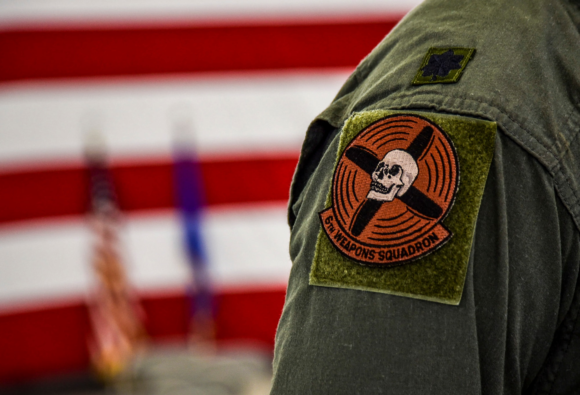 Lt. Col. Michael Blauser, 6th Weapons Squadron commander, displays the 6th WPS patch. The patch has represented the squadron since 1917 and features a skull at the center of spinning propellers. (U.S. Air Force photo by Airman 1st Class Andrew D. Sarver/Released)