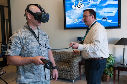 Chief Master Sgt. Edward Slacum (left), 548th Intelligence, Surveillance and Reconnaissance Group superintendent, utilizes a virtual reality headset to explore a C-130 Hercules at Beale Air Force Base, Calif., May 24, 2017. One of the main uses for the VR technology is to provide a hands-on, realistic training environment for Airmen working in intelligence to properly identify aircrafts from various countries. (U.S. Air Force photo by Senior Airman Lauren Parsons/Released)