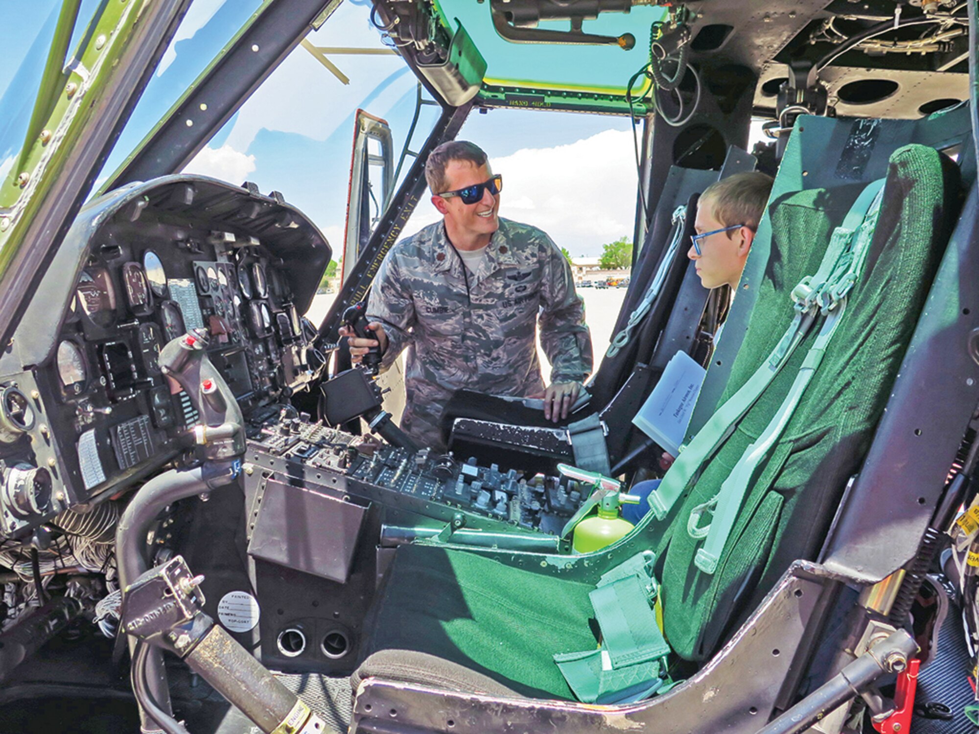 Maj. Frank Cumble, 58th Special Operations Wing, shows Seth Knudsen around the cockpit of a Huey helicopter on Kirtland's flightline. 