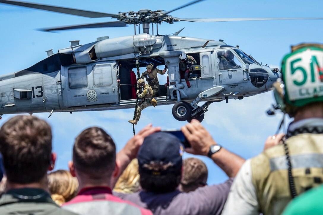 Sailors fast-rope from an MH-60S Seahawk helicopter onto the aircraft carrier USS Carl Vinson during an air power demonstration for visiting friends and family members of the ship’s sailors in the Pacific Ocean, June 18, 2017. Navy photo by Petty Officer 1st Class Julio Rivera