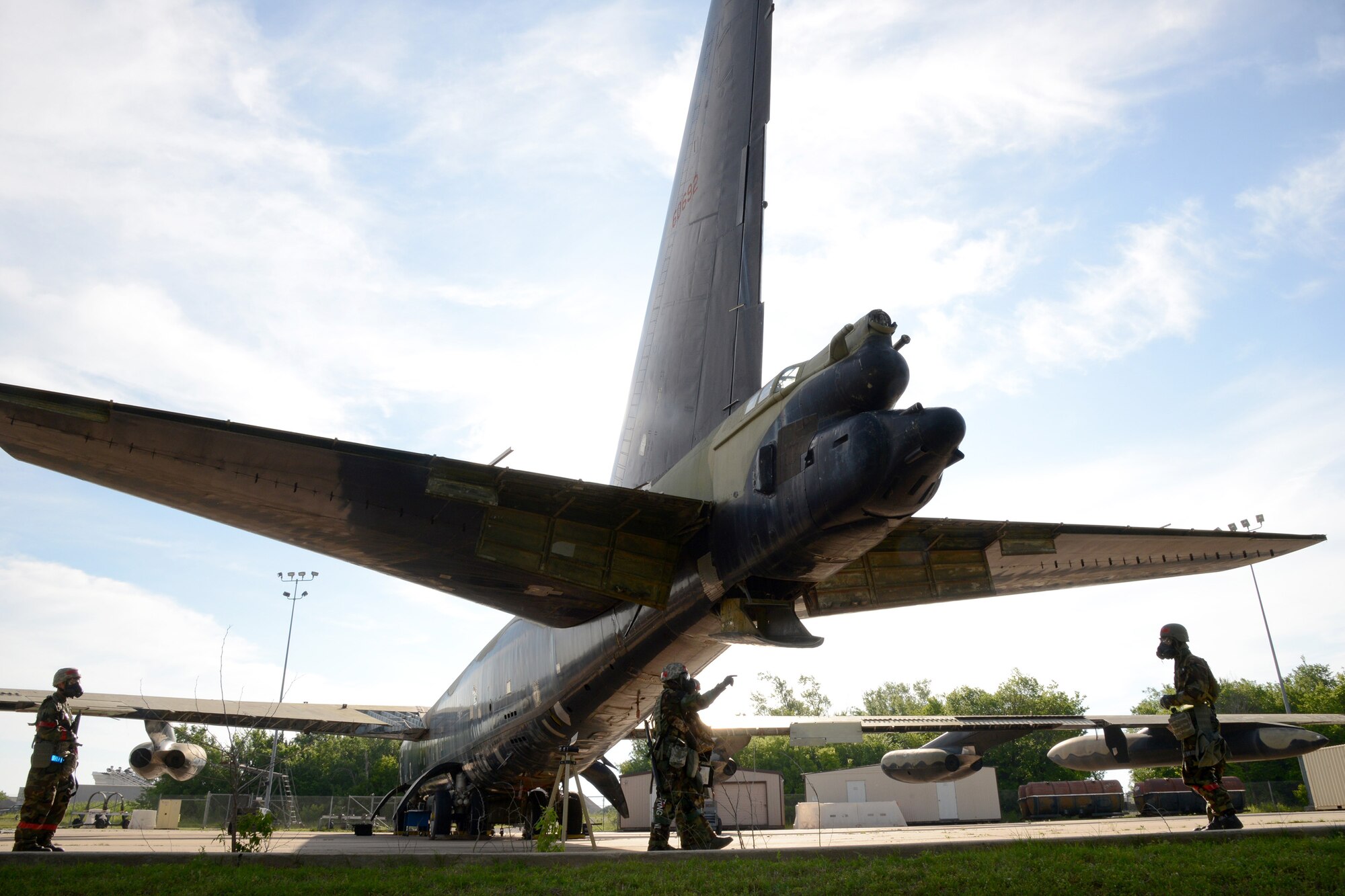 Members of the 76th Aircraft Maintenance Group’s Expeditionary Depot Maintenance Flight sweep the perimeter around a B-52 Stratofortress after a simulated attack on their compound while they were performing aircraft battle damage repairs during a recent war wagon exercise. (Air Force photo by Kelly White)