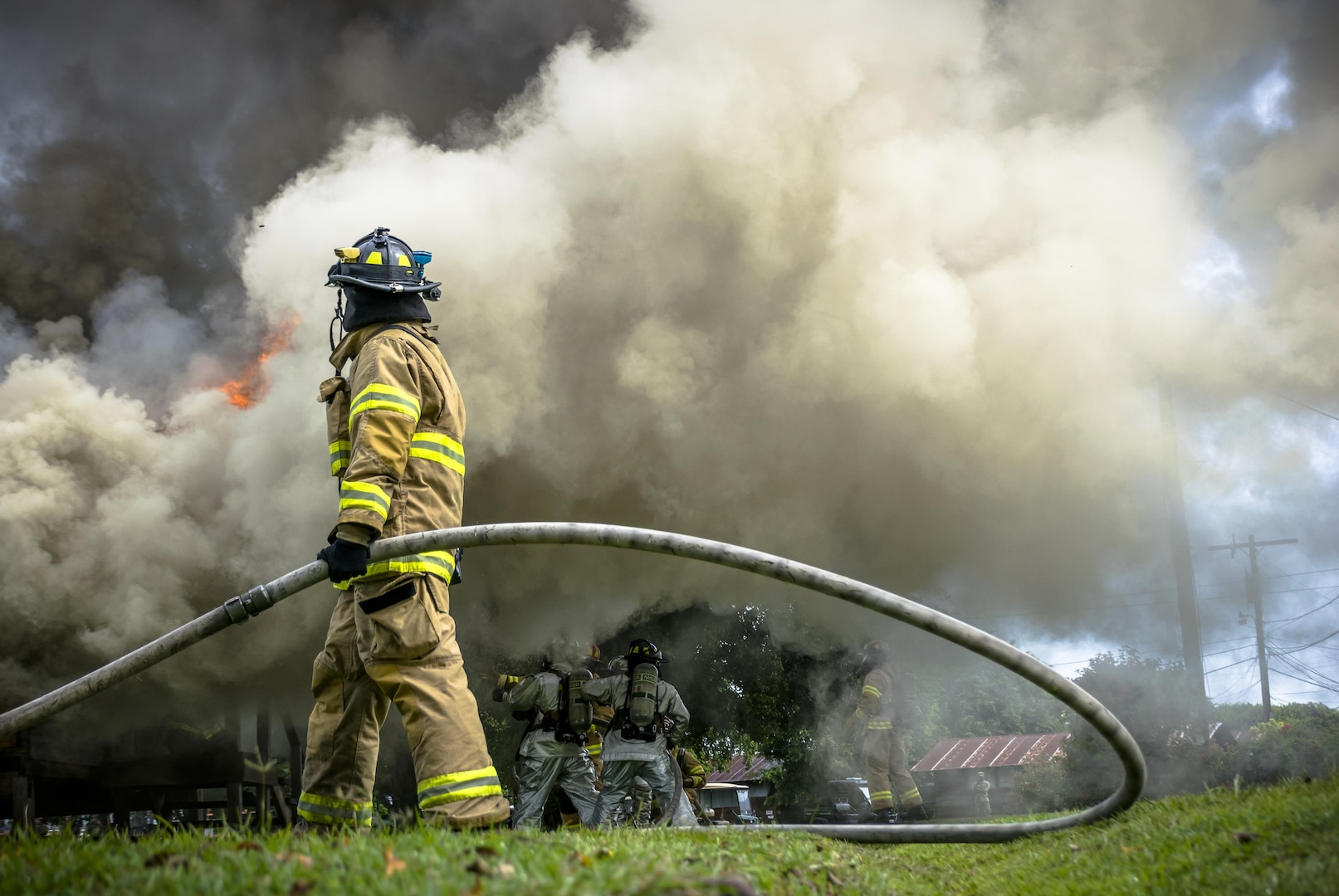 Senior Airman Christopher L. Allen assists his team by helping pull the nozzle through and holding the line as the weight can be taxing. The 612th ABS Fire Department host a public fire training at Soto Cano Air Base, June 16, 2017. (U.S. Air Force photo by Senior Airman Julie Kae/released)