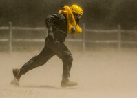 Lt. Col. Brandon Dow, 54th Airlift Squadron, runs through the dust kicked up by a UH-60 Blackhawk during Scott's first-ever water extraction training with the 6-101st Aviation Regiment of Fort Campbell, Ky., Lake Carlyle, Ill., June 7, 2017. Dow, Lt. Col. Brooke Matson, 375th Operations Support Squadron, and Maj. Madison Basil Jr., Headquarters Air Mobility Command, received hoist, water survival, and flare training to learn how to survive in aquatic situations long enough to be rescued. The 101st Combat Aviation Brigade has served in almost every single military operation since the Vietnam War, including combat, peacekeeping, and humanitarian.  By partnering with Air Mobility Command’s SERE instructors, this training allows for joint-service coordination while preparing aerial crew members to survive in austere locations after being displaced from their aircraft.  (U.S. Air Force photo by Staff Sgt. Jodi Martinez)