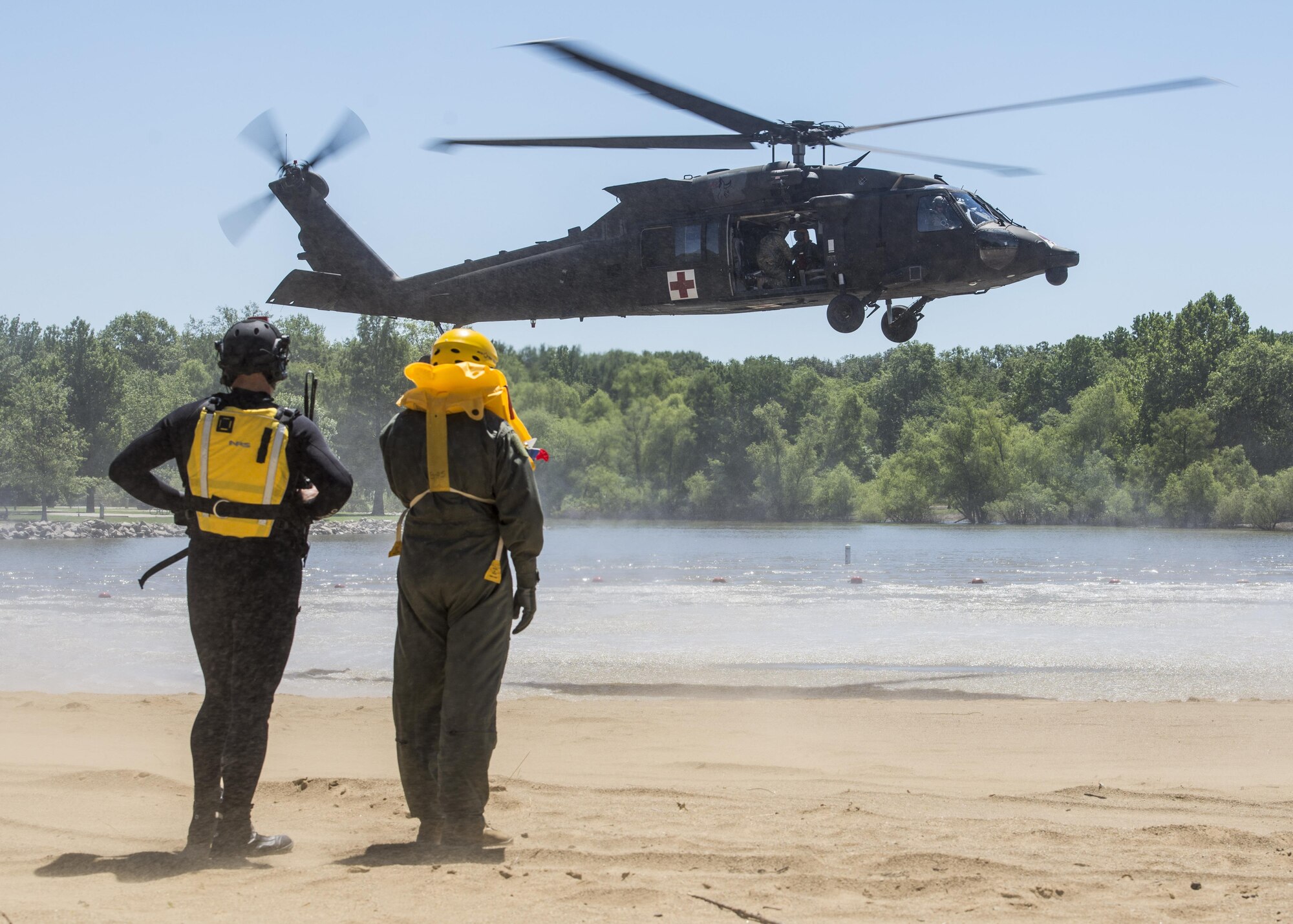 A Survive, Evade, Resist and Escape instructor and Lt. Col. Brandon Dow, 54th Airlift Squadron from Scott Air Force Base,  prepare for their first ever medical evacuation water extraction with the 6-101st Aviation Regiment from Fort Campell, Kentucky at Lake Carlyle, Illinois, June 7, 2017. Dow, Lt. Col. Brooke Matson, 375th Operations Support Squadron, and Maj. Madison Basil Jr., Air Mobility Command, received hoist, water survival and flare training to learn how to survive in aqautic situations long enough to be rescued. The 101st Combat Aviation Brigade has served in almost every single military operation since the Vietnam War, including combat, peacekeeping, and humanitarian. By partnering with AMC's SERE instructors, this training allows for joint-service coordination while preparing aerial crew members to survive in austere locations ater being displaced from their aircraft. (U.S.Air Force photo by Airman 1st Class Daniel Garcia)