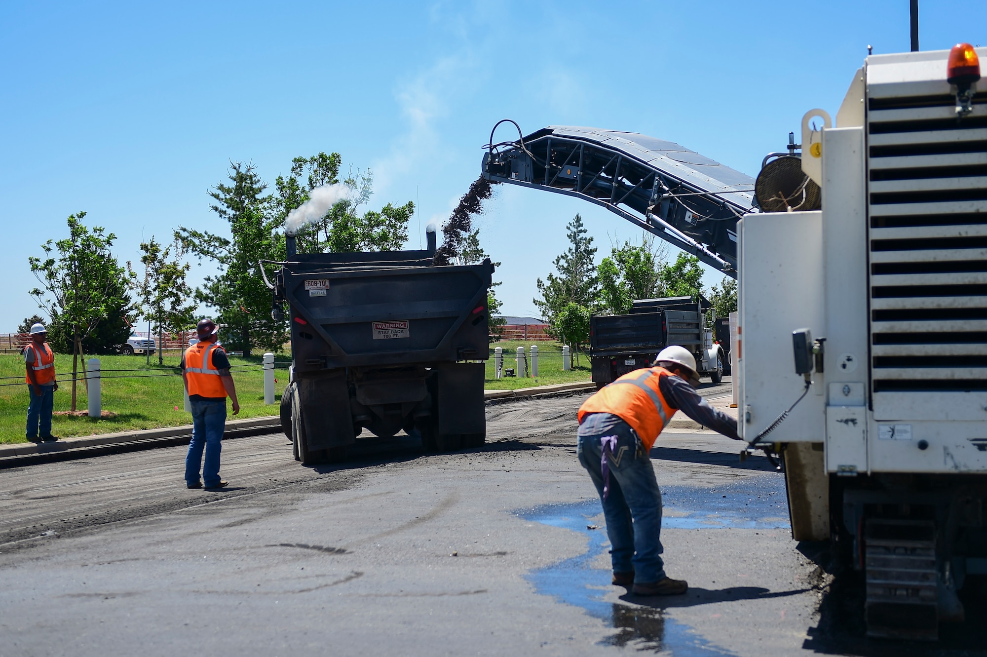 Contractors from Mirador-Nasco remove asphalt from the 6th Avenue Gate outbound lanes June 13, 2017. The reconstruction project is expected to be complete by October, 2017. (U.S. Air Force photo by Airman Jacob Deatherage/Released)