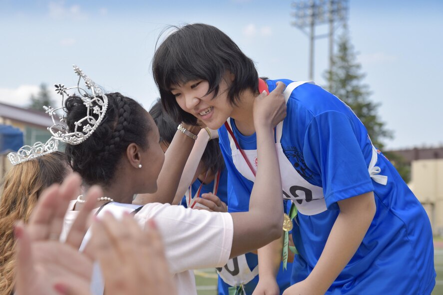 An athlete receives a gold medal from Lesley Ortiz, Mrs.Sakura 2017 contestant, in the standing long jump competition during the 38th Annual Kanto Plains Special Olympics at Yokota Air Base, Japan, June 17, 2017. The Special Olympics is a global organization. The Non Commissioned Officers Association established the KPSO program at Yokota Air Base, Japan with only three athletes from the Department of Defense Education Activity in 1980. In 1984, the KPSO became a separate private organization. (U.S. Air Force photo by Machiko Arita)