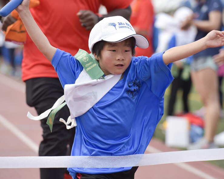 An athlete crosses the finish line during the 400 meters relay at the 38th Annual Kanto Plains Special Olympics at Yokota Air Base, Japan, June 17, 2017. The Special Olympics provides people with intellectual disabilities continuing opportunities to realize their potential, develop physical fitness, demonstrate courage, experience joy and friendship.  (U.S. Air Force photo by Machiko Arita)
