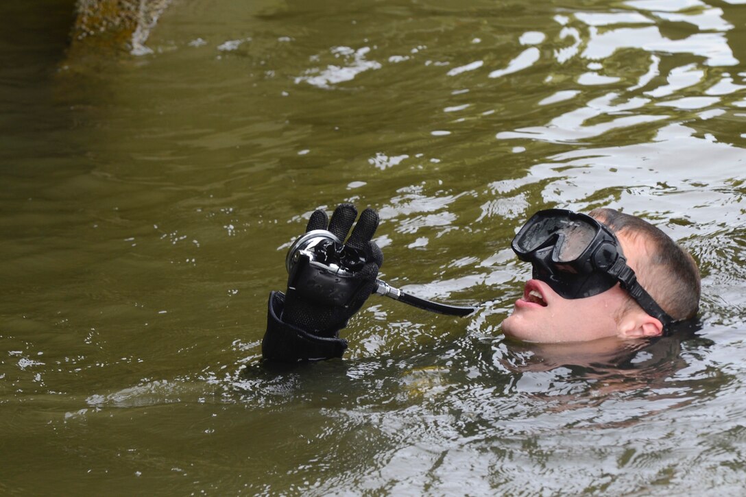 U.S. Army Pfc. Samuel Ladd, 74th Engineer Dive Detachment, 92nd Eng. Battalion second class diver, calls out findings from an inspection of Third Port’s piers during a diving mission at Joint Base Langley-Eustis, Va., June 20, 2017. Along with scuba equipment, the divers have surface-supply diving equipment, which is used for dives that require constant communication with the team. (U.S. Air Force photo/Airman 1st Class Kaylee Dubois)