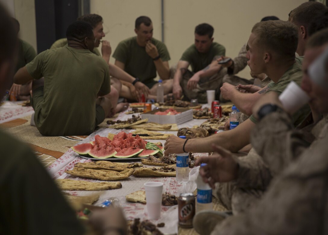 U.S. Marines with team police, Task Force Southwest, enjoy the fresh watermelon and goat at Bost Airfield, Afghanistan, June 21, 2017. A local village elder brought fresh watermelon, bread and cooked three goats to serve as a welcome and thank you gift to the team police Marines. Task Force Southwest, comprised of approximately 300 Marines and Sailors from II Marine Expeditionary Force, are training, advising and assisting the Afghan National Army 215th Corps and the 505th Zone National Police. (U.S. Marine Corps photo by Sgt. Justin T. Updegraff)