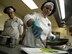 U.S. Air Force Senior Master Sgt. Teresa Vanderford, Air Force General Officer Management Office enlisted aide program manager, right, plates sautéed asparagus at the Gateway Dining Facility on RAF Mildenhall, England, June 8, 2017. The weeklong training took place to reinforce attention to detail and encourage cooks to take pride in their work. (U.S. Air Force photo by Senior Airman Justine Rho)