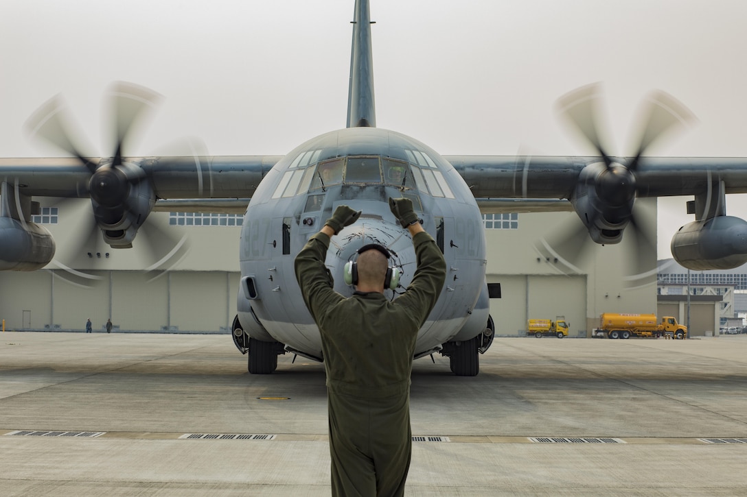 U.S. Marine Corps Sgt. Ryan Flores, a crew master with Marine Aerial Refueler Transport Squadron 152, guides a KC-130J Hercules into a set of hot refuel pits at Marine Corps Air Station Iwakuni, Japan, June 20, 2017. U.S. Marines, U.S. Sailors and Master Labor Contractors with Headquarters and Headquarters Squadron fuels division conducted a proof of concept for hot refueling in order to test for safety and ensure all equipment functioned properly. Pending approval from the air station’s commanding officer and the Defense Logistics Agency, the rebuilt hot refuel pits will allow aircraft to rapidly refuel without powering down their engines, which increases operational readiness.