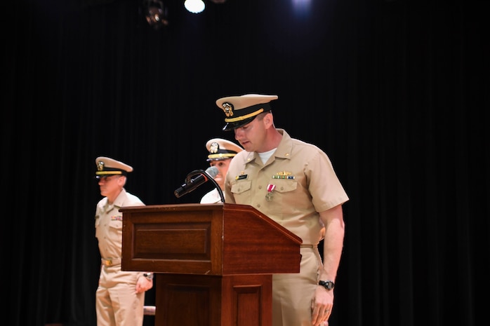 170615-N-TB177-0019 MANAMA, Bahrain (June 15, 2017) Lt. Cmdr. Robert Burke, former commanding officer of USS Devastator (MCM 6), reads his departing orders during a change of command ceremony at Naval Support Activity Bahrain. Devastator is the sixth of 14 Avenger-class mine countermeasures ships and the second ship to bear its name. (U.S. Navy photo by Mass Communication Specialist 2nd Class Kevin J. Steinberg)
