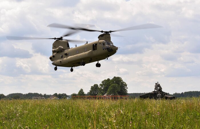 A U.S. Army CH-47 Chinook helicopter flies towards Airmen assigned to the 435th Contingency Response Group, Ramstein Air Base, Germany, during exercise Saber Strike 17 at Lielvarde Air Base, Latvia, June 10, 2017. The 435th CRG Airmen worked alongside U.S. Army and NATO military members throughout the exercise. Saber Strike 17 continues to increase participating nations’ capacities to conduct a full spectrum of military operations. (U.S Air Force photo by Senior Airman Tryphena Mayhugh)