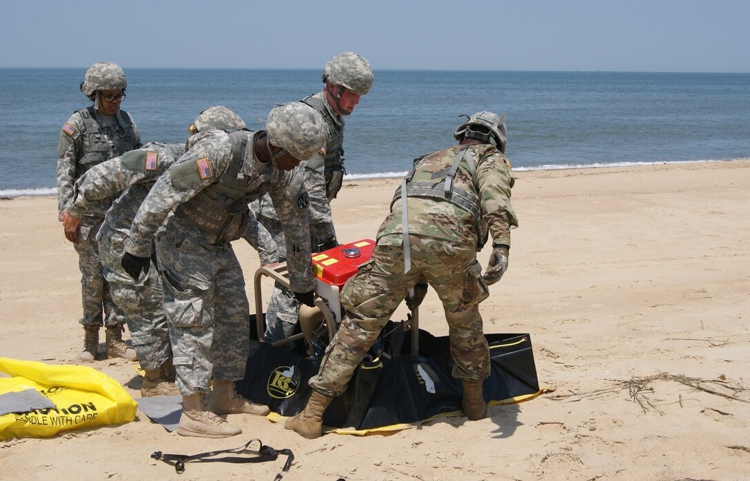 The Army National Guard water purification team from the 125th Quartermaster Company, Massachusetts, sets the cyclone separator in its place as part of the Reverse Osmosis Water Purification Unit Rodeo at Fort Story, Virginia, June 12, 2017.