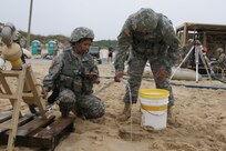 (Left to right) Sgt. Monika MacDonald and Private 1st Class Miguel Arroyo, members of the 753rd Quartermaster Company water purification team, drain the cyclone separator as they shut down operations at the Reverse Osmosis Water Purification Unit Rodeo at Fort Story, Virginia, June 15, 2017.