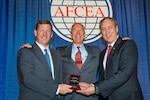 R. Dempsey Hackett (left), director of Technology Foundation Services and Robert Foster (right), deputy director of DLA Information Operations, accept the 2017 Distinguished Award for Excellence from Allan Mink of Systems Spirit LLC (center), at the 2017 AFCEA Awards.