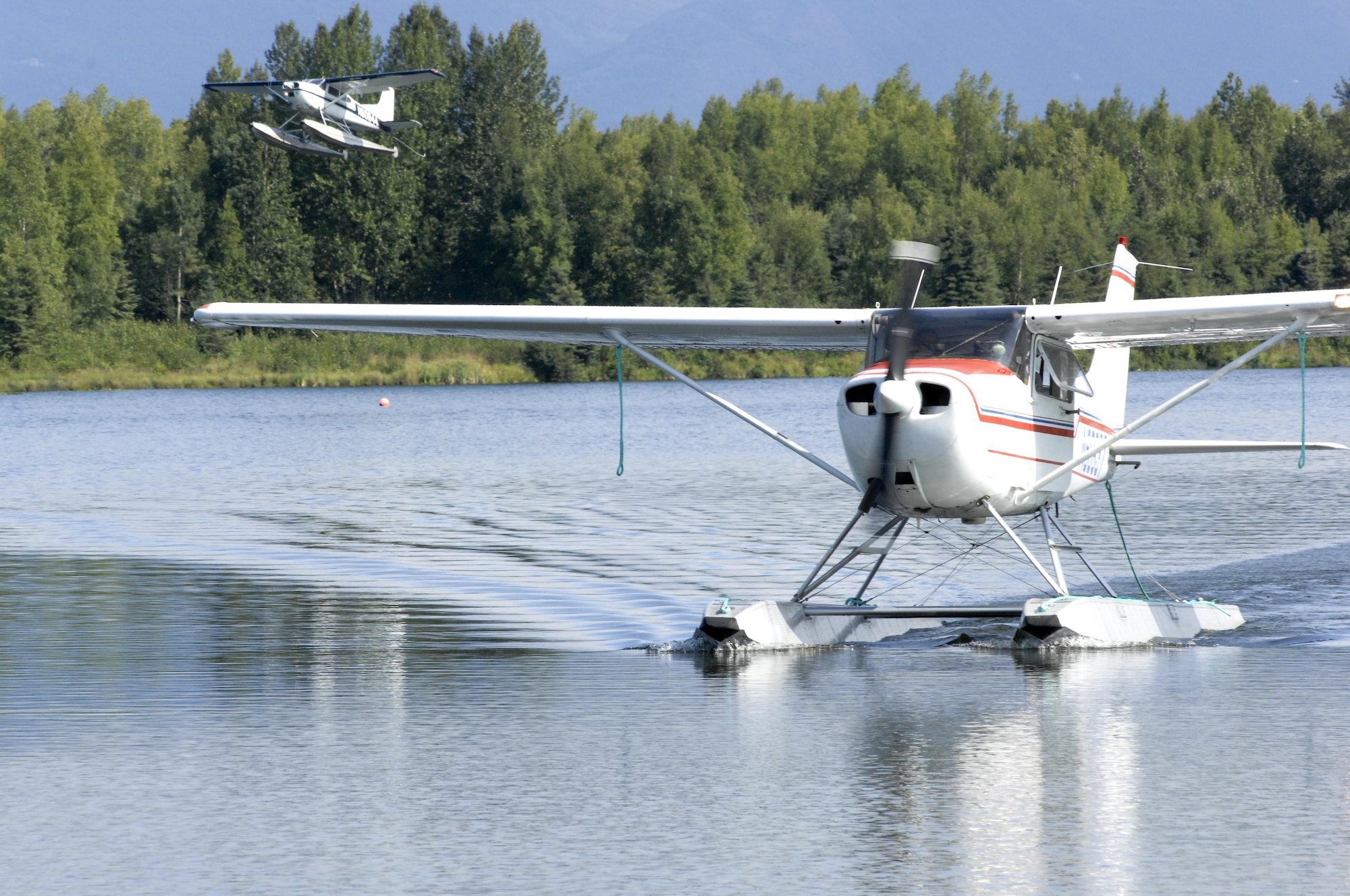 An Elmendorf Aero Club Cessna 172 float plane taxis in while a Cessna 185 takes off at Six-Mile Lake, Alaska. The Elmendorf Aero Club is the only Air Force Aero Club that offers float planes.(U.S. Air Force photo/Airman Jack Sanders)