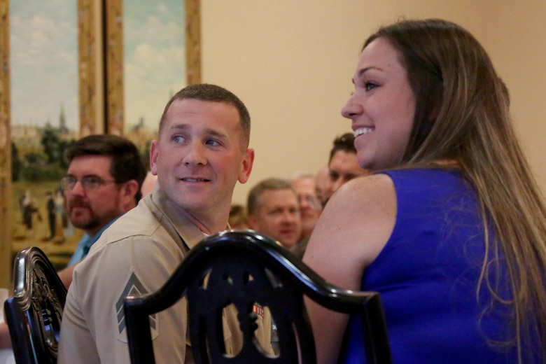 Sgt. Shaun Monaghan and his wife, Lindsay, listen to a speech while being recognized as the Military Family of the Quarter during a luncheon at the New Bern, N.C., Golf and Country Club, June 9, 2017. The Monaghans have contributed hundreds of volunteer hours to the New Bern community. Shaun is an intermediate level ordnance instructor at the Center for Naval Aviation Technical Training aboard Marine Corps Air Station Cherry Point, N.C. (Marine Corps photo by Cpl. Jason Jimenez/ Released)