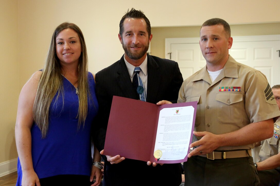 A proclamation from the city of New Bern is given to Sgt. Shaun Monaghan and his wife Lindsay while being recognized as the Military Family of the Quarter during a luncheon at the New Bern, N.C., Golf and Country Club, June 9, 2017. The Monaghans have contributed hundreds of volunteer hours to the New Bern community. Shaun is an intermediate level ordnance instructor teaching hundreds of Marines at the Center for Naval Aviation Technical Training aboard Marine Corps Air Station Cherry Point, N.C. (Marine Corps photo by Cpl. Jason Jimenez/ Released)
