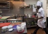 170616-N-ZV163-375 MANAMA, Bahrain (June 16, 2017) Culinary Specialist 2nd Class Matthew Ndambuki, a chef de cuisine trainee from Detroit, walks to his cooking station inside the U.S. Naval Forces Central Command (NAVCENT) headquarters Flag Mess onboard Naval Support Activity Bahrain, June 16. Ndambuki passed the American Culinary Federation certification test to further his expertise in the culinary arts. This skill aids the NAVCENT commander with achieving objective and reaching common goals with leaders in the region by enabling them to sit down to a attractive and appealing meal. (U.S. Navy photo by Mass Communication Specialist 2nd Class Christina Brewer)