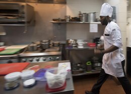 170616-N-ZV163-375 MANAMA, Bahrain (June 16, 2017) Culinary Specialist 2nd Class Matthew Ndambuki, a chef de cuisine trainee from Detroit, walks to his cooking station inside the U.S. Naval Forces Central Command (NAVCENT) headquarters Flag Mess onboard Naval Support Activity Bahrain, June 16. Ndambuki passed the American Culinary Federation certification test to further his expertise in the culinary arts. This skill aids the NAVCENT commander with achieving objective and reaching common goals with leaders in the region by enabling them to sit down to a attractive and appealing meal. (U.S. Navy photo by Mass Communication Specialist 2nd Class Christina Brewer)