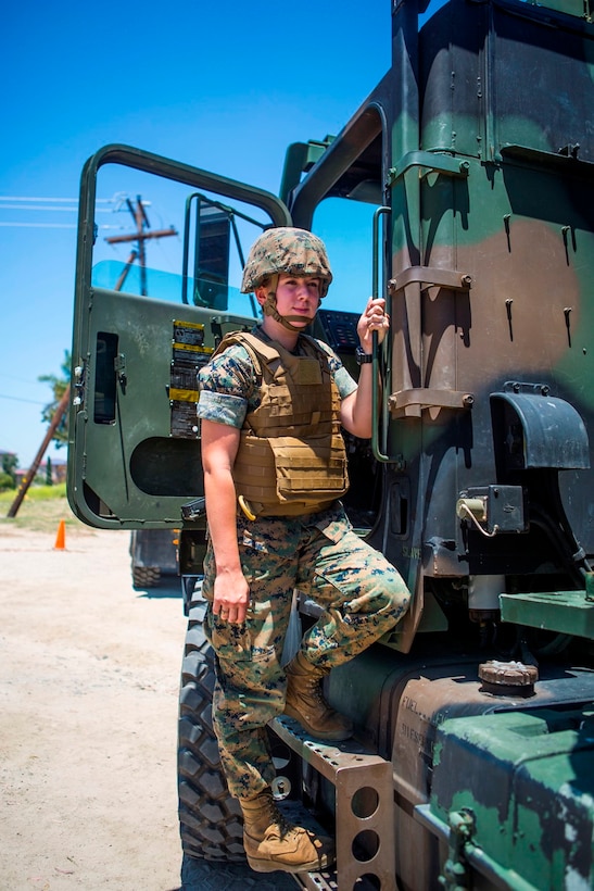 U.S. Marine Pfc. Heather Bartulewicz, a motor transport operator with Headquarters Regiment, 1st Marine Logistics Group, poses for a picture before climbing into a Medium Tactical Vehicle Replacement MK23 truck as she prepares to transport mission essential gear from one location to the next on Camp Pendleton, Calif., June 20, 2017. Motor Transport operators maintain and operate both commercial and tactical vehicles and are responsible for the transportation of everything from supplies and resources, to Marines and their equipment. (U.S. Marine Corps photo by Lance Cpl. Joseph Sorci)