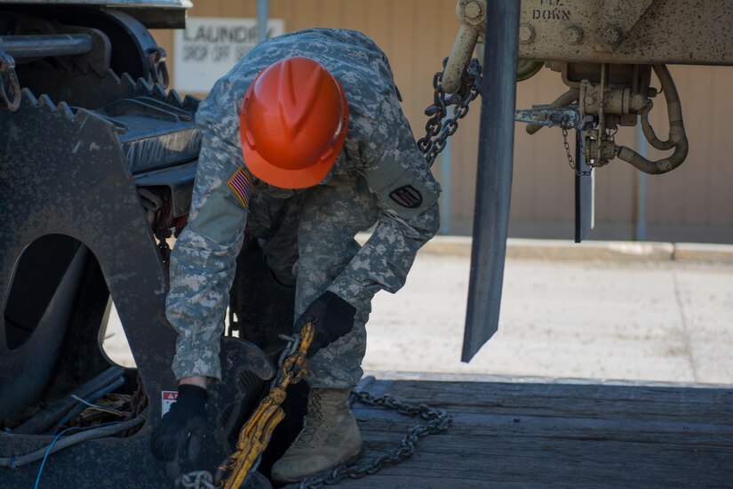 Spc. Seth Trobaugh, a fuel distribution specialist from the 317th Engineer Company, releases the chains and binders that keep the M978A4 HEMTT fueler truck secured to the low-boy trailer, June 6, 2017. The fueler was shipped to Browning, Montana to provide a way to fuel the multiple pieces of construction equipment that will be used during the 317th’s Innovative Readiness Training (IRT) project. The IRT project produces military readiness while simultaneously providing quality services to communities throughout the U.S. This particular project takes place on the Blackfeet Reservation in Browning Montana during the months of June thru August (U.S. Army photo by Staff Sgt. Jason Proseus/released).