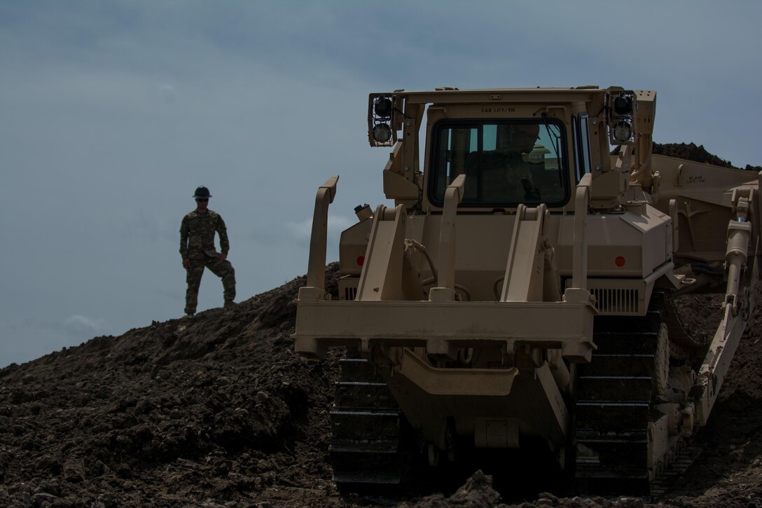 Staff Sgt. Jonathan Kline, a horizontal construction supervisor with the 317th Engineer Company and project noncommissioned officer in charge, watches Pfc. Daniel Valdavenos operate a T-9/D7R medium dozer. Valdavenos is receiving "stick time" in order to re-familiarize himself with the equipment as the 317th prepares to take part in Innovative Readiness Training (IRT). The IRT project produces military readiness while simultaneously providing quality services to communities throughout the U.S. This particular project takes place on the Blackfeet Reservation in Browning, Montana during the months of June thru August (U.S. Army photo by Staff Sgt. Jason Proseus/released).