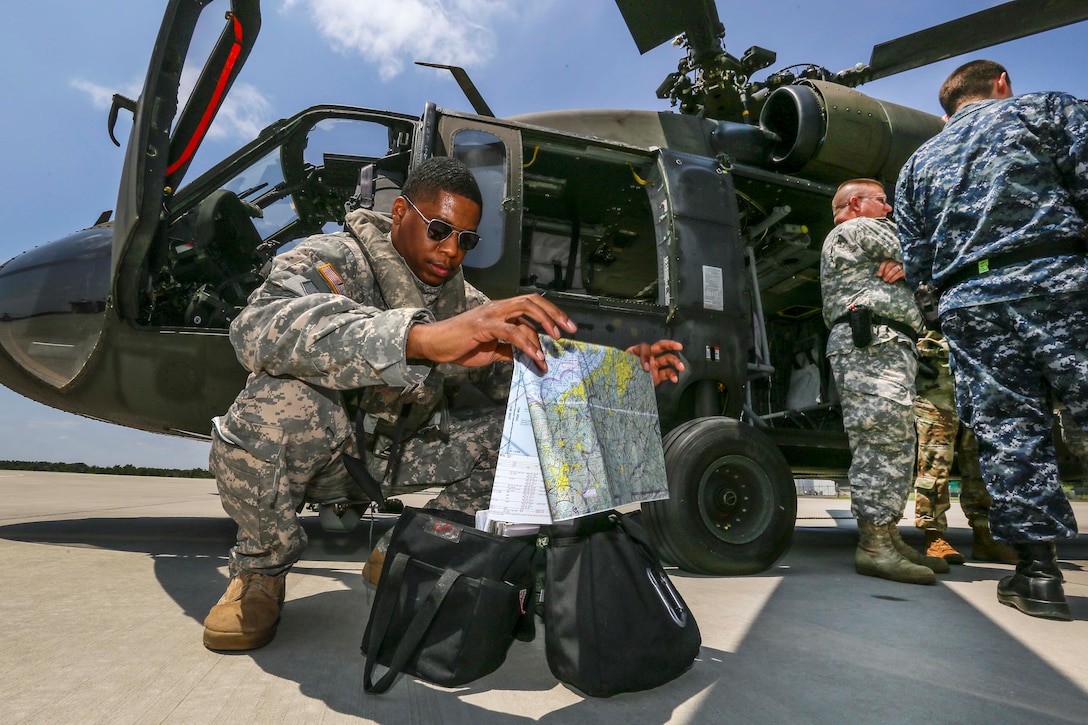 New Jersey Army National Guard Capt. Andre Stevenson, left, looks over maps before a training flight at Joint Base McGuire-Dix-Lakehurst, N.J., June 14, 2017. Stevenson is a pilot assigned to Delta Company, 1st Battalion, 150th Aviation Regiment. New Jersey Air National Guard photo by Master Sgt. Matt Hecht