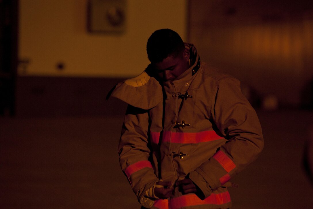 A U.S. Marine assigned to the Fire Protection Apprentice Course, Marine Detachment Goodfellow, prepares his gear to conduct ladder training exercises at Joint Airforce Base Goodfellow, Texas, March 24, 2017. The mission of Marine Detachment Goodfellow is to train Marines in the occupational fields of Fire Protection and Signals Intelligence for the Fleet Marine Force. (U.S. Marine Corps photo by Lance Cpl. Jose Villalobosrocha)