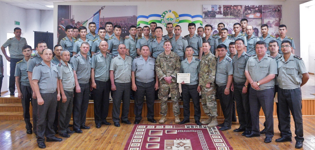 Staff Sgt. Joshua Atanovich, center, and Staff Sgt. William Gordley, center right, both with U.S. Army Central Command’s 149th Military Engagement Team, take a final group photo with the Uzbek audience concluding the tactical communications military-to-military engagement June 13-16, 2017, at the Tashkent Institute of Information Technologies in Tashkent, Uzbekistan. (courtesy photo)